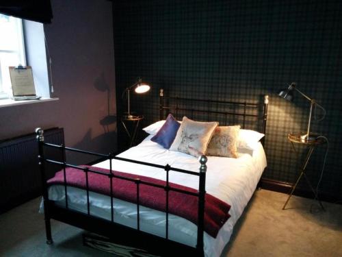 1 dormitorio con 1 cama con sábanas y almohadas blancas en The Manners Pub with Rooms, en Bakewell