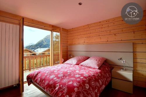een slaapkamer met een bed en een groot raam bij L'Eden in Ovronnaz