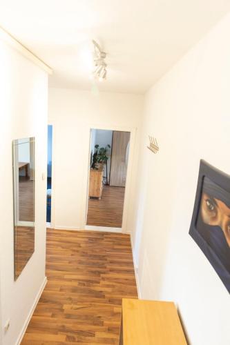 a living room with white walls and a wooden floor at AVR Geestemünde 6 in Bremerhaven