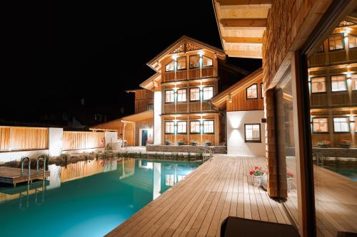 a house with a swimming pool at night at DAS SALZBERG Hideaway Bad Aussee - Adults only in Bad Aussee