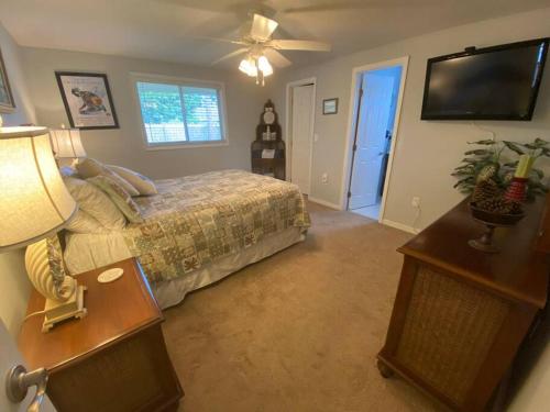 a bedroom with a bed and a flat screen tv at Salt water pool house near beach for monthly rental in Venice