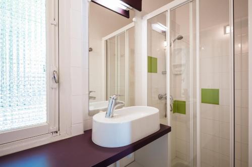 une salle de bain blanche avec un lavabo et une douche dans l'établissement Camping - Village Vacances Familial à Prayssac au coeur du vignoble Lotois, à Prayssac
