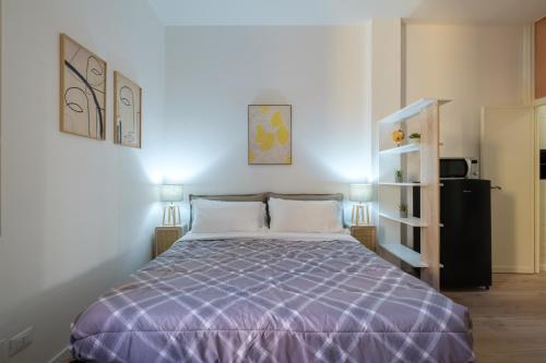 1 dormitorio con 1 cama con edredón morado en Casa del Laureato by Studio Vita, en Bolonia