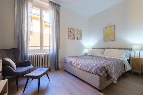 1 dormitorio con 1 cama, 1 silla y 1 ventana en Casa del Laureato by Studio Vita, en Bolonia