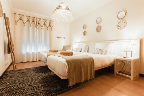 a bedroom with two beds and a chandelier at Sunshine Beach Apartment in Leiria