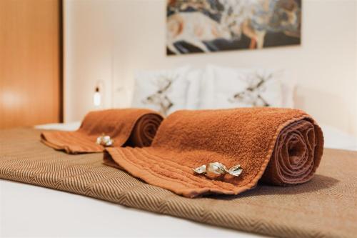 a pair of towels sitting on top of a bed at Sunshine Beach Apartment in Leiria