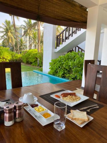 a table with two plates of food on it at The Pleasure Kosgoda in Bentota