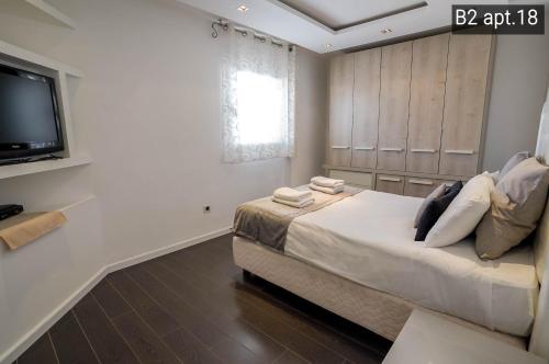 a bedroom with a large bed and a flat screen tv at Palmore Resort apartments in Eilat