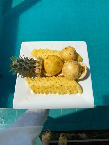 a plate of food with a pineapple and crackers at The Pleasure Kosgoda in Bentota