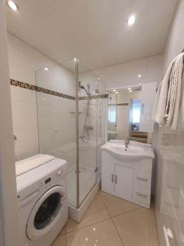 a white bathroom with a washing machine and a sink at Central City Apartment Vienna in Vienna