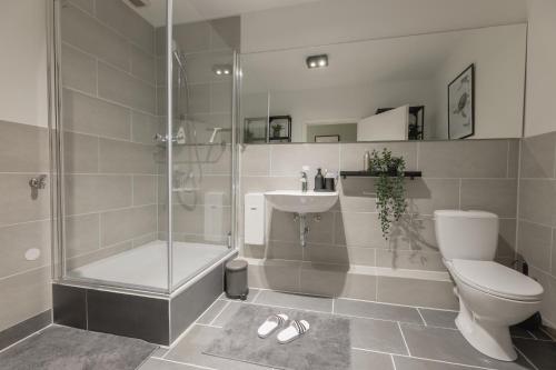 La salle de bains est pourvue d'une douche, de toilettes et d'un lavabo. dans l'établissement The Harbour Apartment 1, à Hambourg