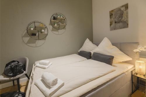 a bed with white sheets and towels on it at The Harbour Apartment 1 in Hamburg