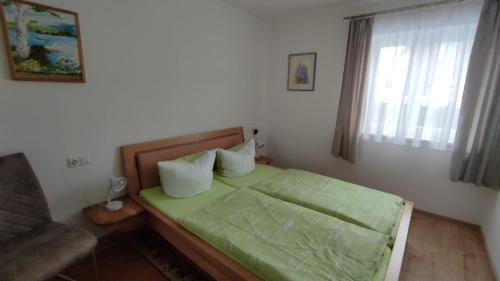 a bedroom with a green bed with a couch and a window at Ferienwohnung Familie Stahl in Seeg