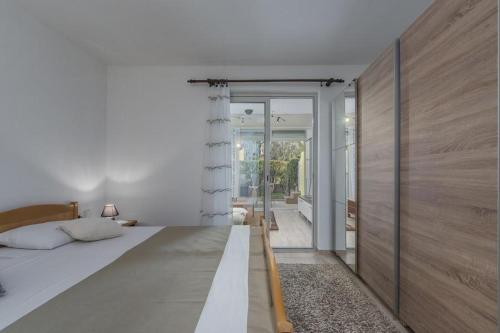 una camera con un grande letto e una porta scorrevole in vetro di Apartment Lana a Novigrad Istria