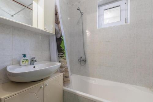 a bathroom with a sink and a shower and a tub at Apartments Lovely Katarina in Karigador