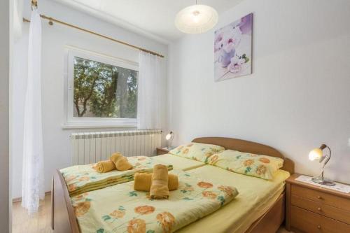 a bedroom with a bed with two teddy bears on it at Apartments Lovely Katarina in Karigador