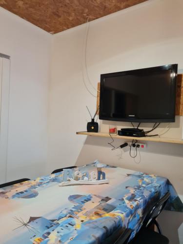 a bedroom with a bed and a flat screen tv at Casas de praia Sandra e Nelson in Almada