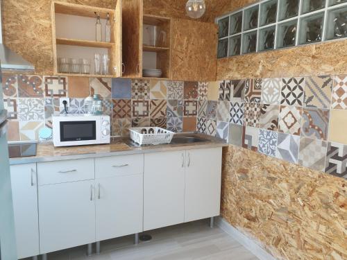 una cocina con armarios blancos y azulejos en la pared en Casas de praia Sandra e Nelson, en Almada