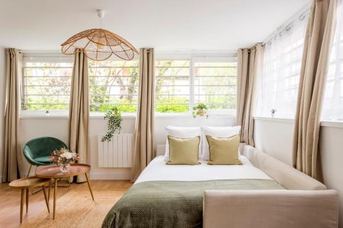 een slaapkamer met een bed, een stoel en ramen bij Cosy 7 Bedrooms with 3 bathrooms - Le Marais in Parijs