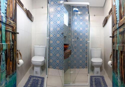 a bathroom with two toilets and a shower at Pousada Guaricana in Pontal do Paraná