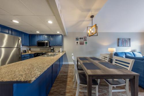 a kitchen with blue cabinets and a wooden table with chairs at Park Plaza Resort - Park City, Ascend Collection Hotel in Park City
