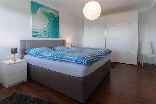 Schlafzimmer mit einem Bett mit blauer Decke in der Unterkunft Ferienwohnung Offermann in Hürtgenwald