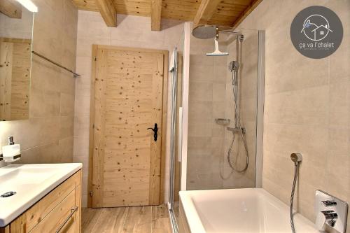 een badkamer met een douche, een bad en een wastafel bij Chalet de charme l'O in Ovronnaz