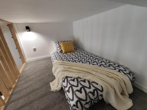 a bedroom with a black and white bed with a yellow pillow at Precioso apartamento en Puente Vallecas, Madrid. D in Madrid