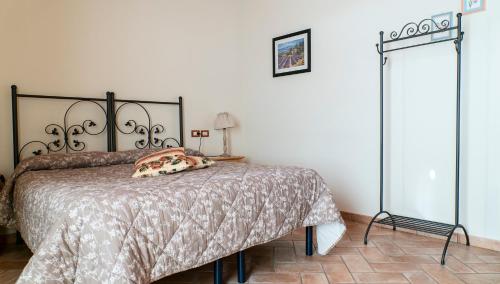 a bedroom with a bed with a blanket and a lamp at Agriturismo Le Tese in Colà di Lazise
