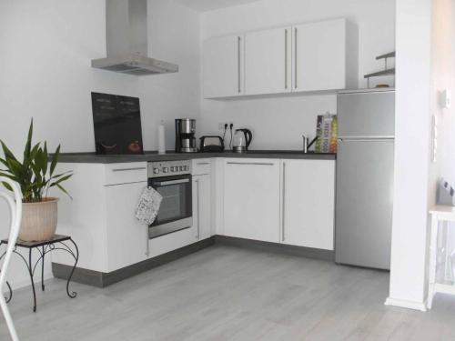 uma cozinha com armários brancos e um forno com placa de fogão em Ferienhaus Nikita em Würzburg