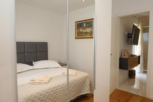 a bedroom with a bed and a mirror at Dalmata D in Podstrana