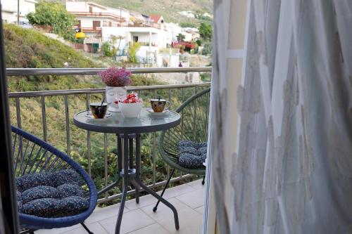 a table on a balcony with two chairs and drinks at Dalmata D in Podstrana