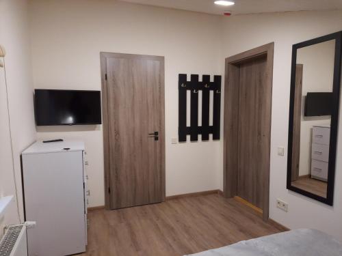 Pokój z 2 drewnianymi drzwiami i telewizorem w obiekcie Шале АНСО w mieście Mikuliczyn