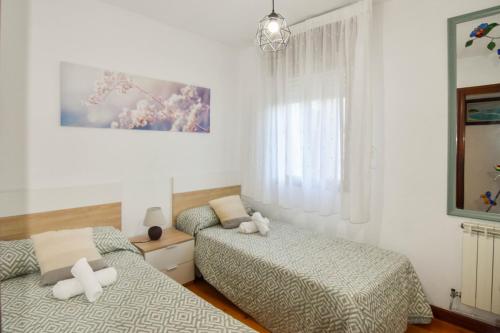sypialnia z 2 łóżkami i oknem w obiekcie Amplio y cómodo chalet en Ajo con preciosas vistas w mieście Ajo