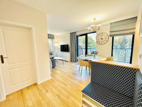 Una sala de estar con una mesa y un comedor. en Baltic View Apartament - Dwie Sosny, en Ustronie Morskie