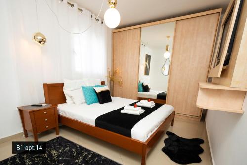 a small bedroom with a bed with a mirror at Palmore Resort apartments in Eilat
