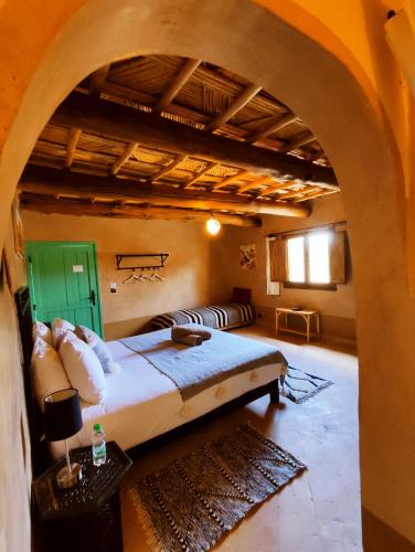 a bedroom with a bed in a room with an archway at Maison d'hôtes Tigminou - Adults Only in Aït Ben Haddou