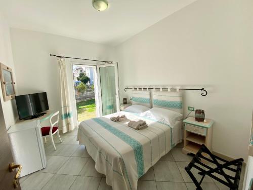 a bedroom with a bed and a tv and a window at Tigrillo Bed&Breakfast in Olbia