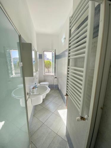 a white bathroom with a sink and a shower at Tigrillo Bed&Breakfast in Olbia