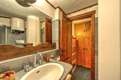 uma casa de banho com um lavatório e uma porta de madeira em Appartamento Eve em Courmayeur