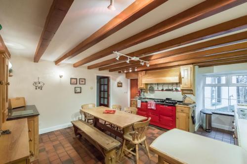 eine Küche mit Holzdecken sowie einem Holztisch und Stühlen in der Unterkunft Rossie Ochil House with Hot Tub in Forgandenny