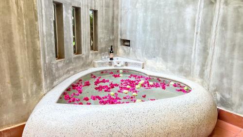 a bathroom with a bath tub filled with pink flowers at SANNA VILLA Residence in Siem Reap