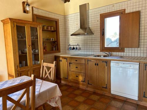 eine Küche mit Holzschränken und einem weißen Geschirrspüler in der Unterkunft Casa Rural Ocre in Avila