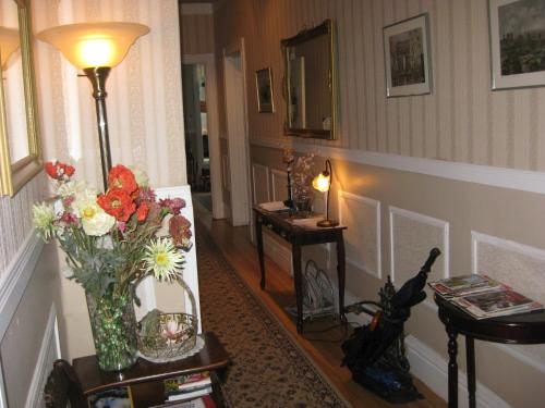 a hallway with a vase of flowers on a table at B&B Le Transit in Quebec City
