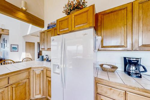 a kitchen with a white refrigerator and wooden cabinets at ShellSeeker in South Beach