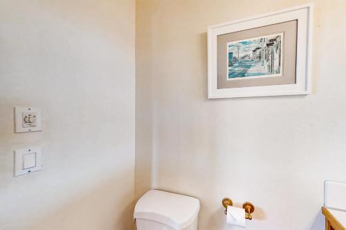 a bathroom with a toilet and a picture on the wall at ShellSeeker in South Beach