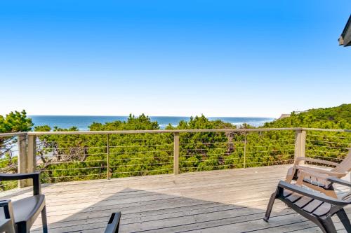 a deck with chairs and the ocean in the background at ShellSeeker in South Beach