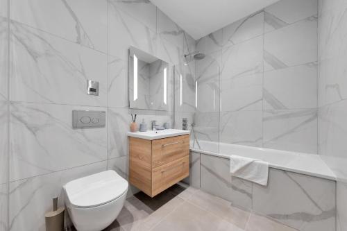 a bathroom with a toilet and a sink and a tub at SERCASA - Appletree Court - Kingston in Kingston upon Thames