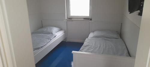 2 camas en una habitación pequeña con ventana en Ferienhaus an der Sternwarte, en Rudolstadt