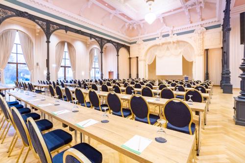 a large room with long tables and chairs at mightyTwice Hotel Dresden in Dresden